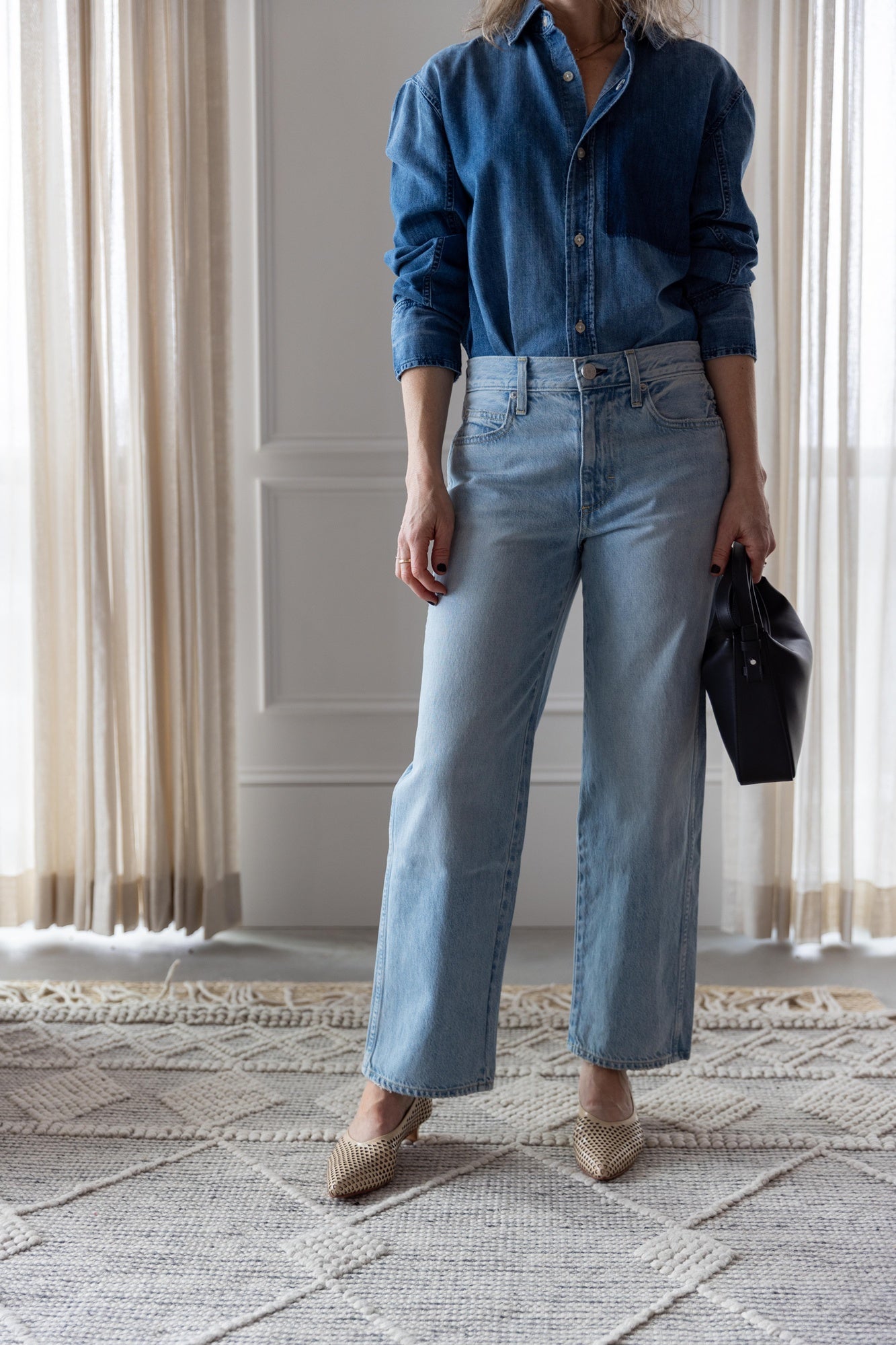 image of woman wearing the Amo Ruth denim shirt and billie jeans with the Aesther Ekme Baguette Bag