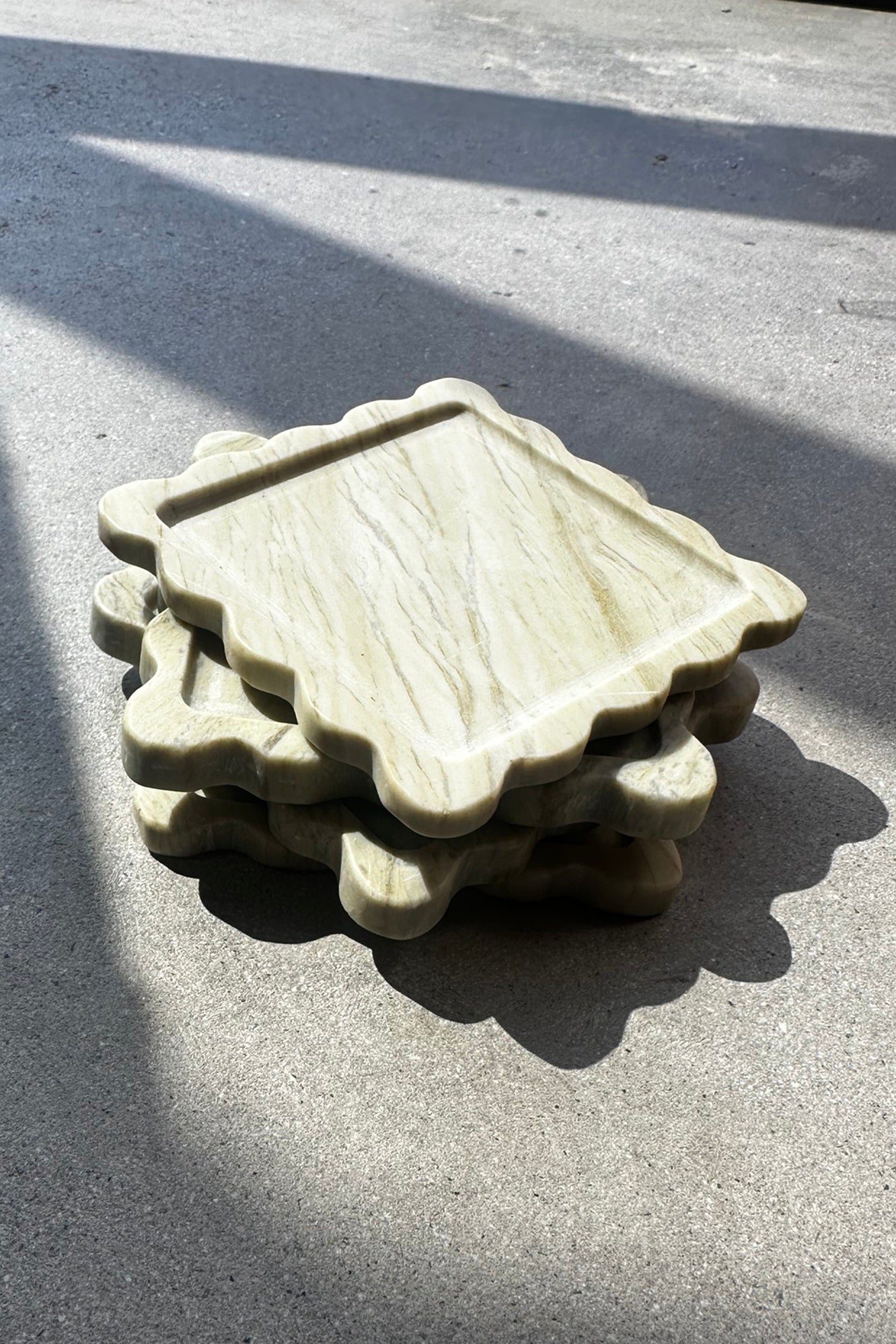 Stack of stone coasters on a concrete surface