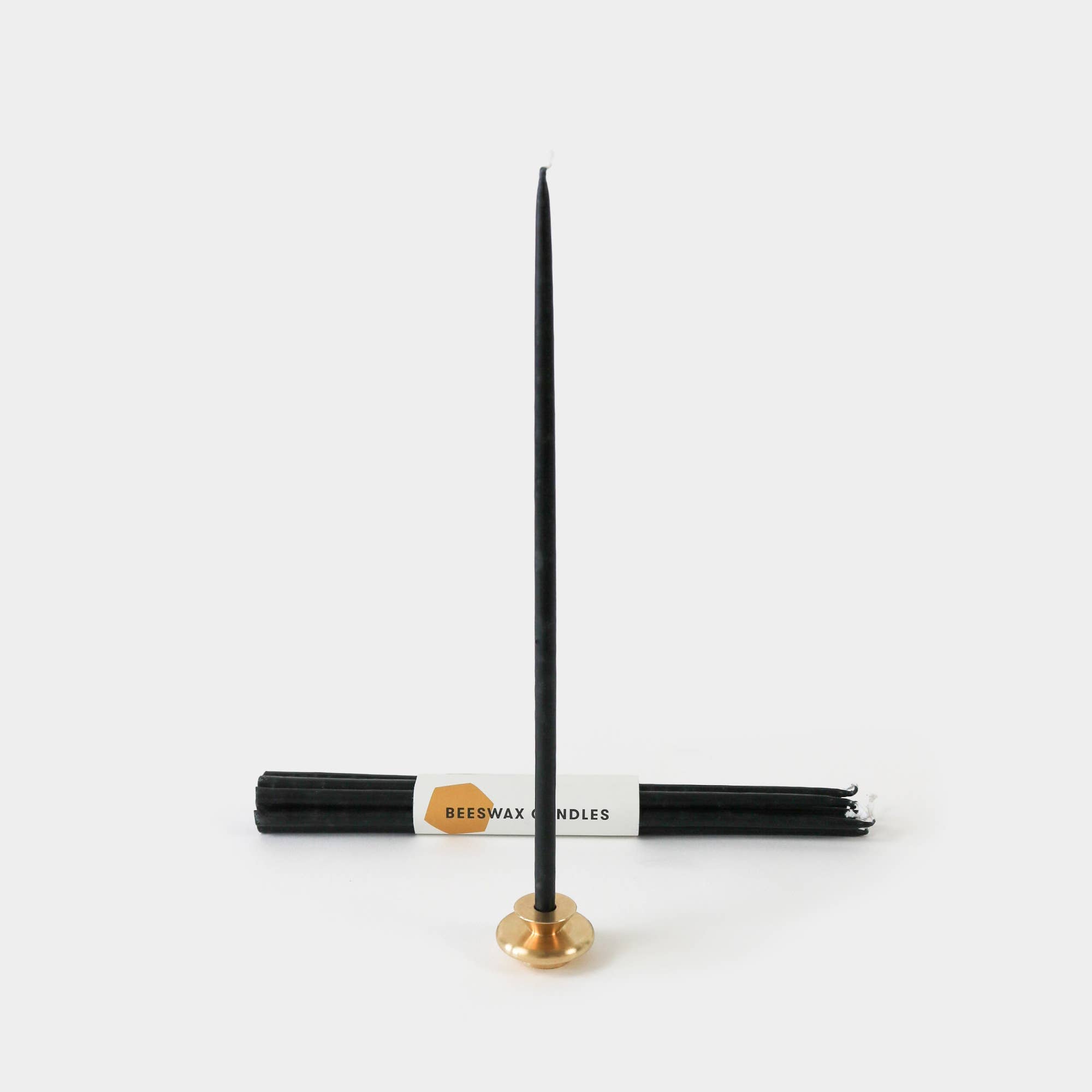 Beeswax candles with a gold holder on a white background