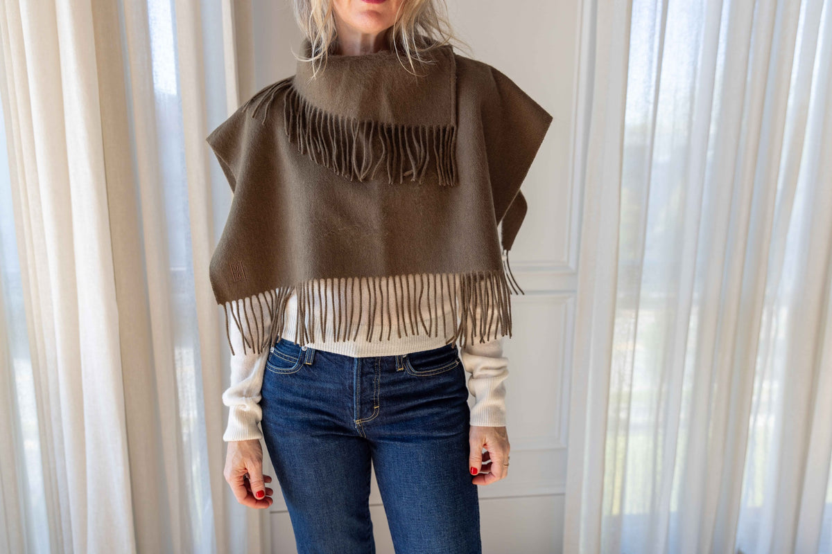 by Malene Birger Turtla in Hunt olive with fringed trim, styled with a cream knit and blue jeans, wide view