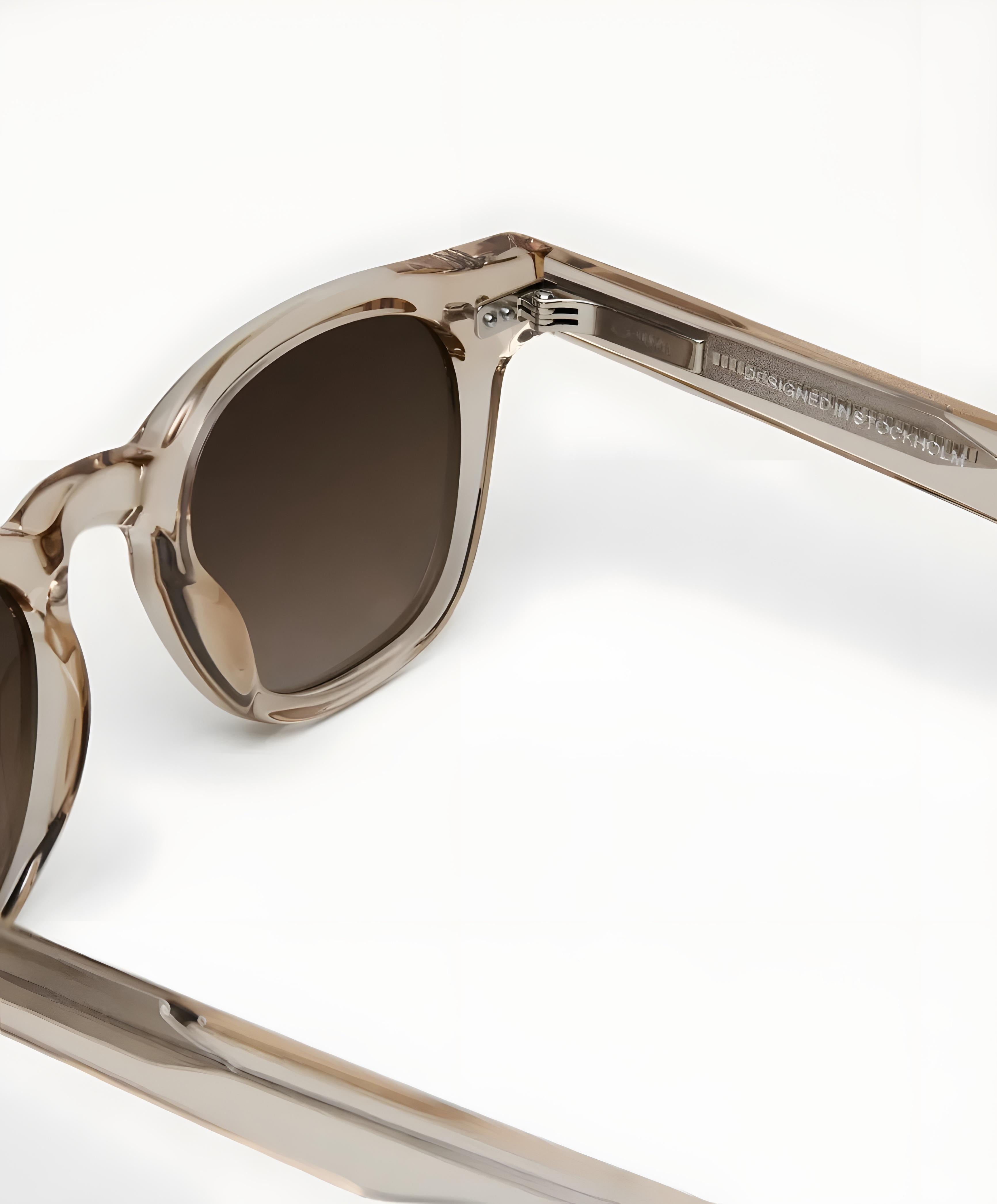 Sunglasses with brown lenses and clear frame on a white background