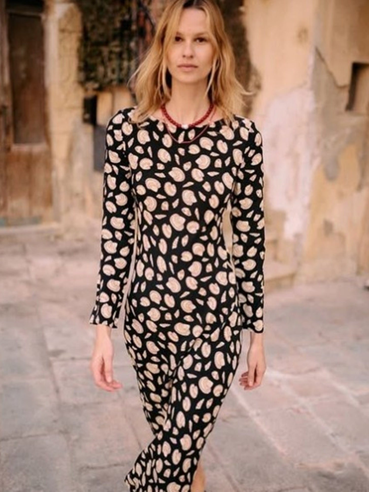 Woman wearing a black dress with pink leopard print in an urban setting
