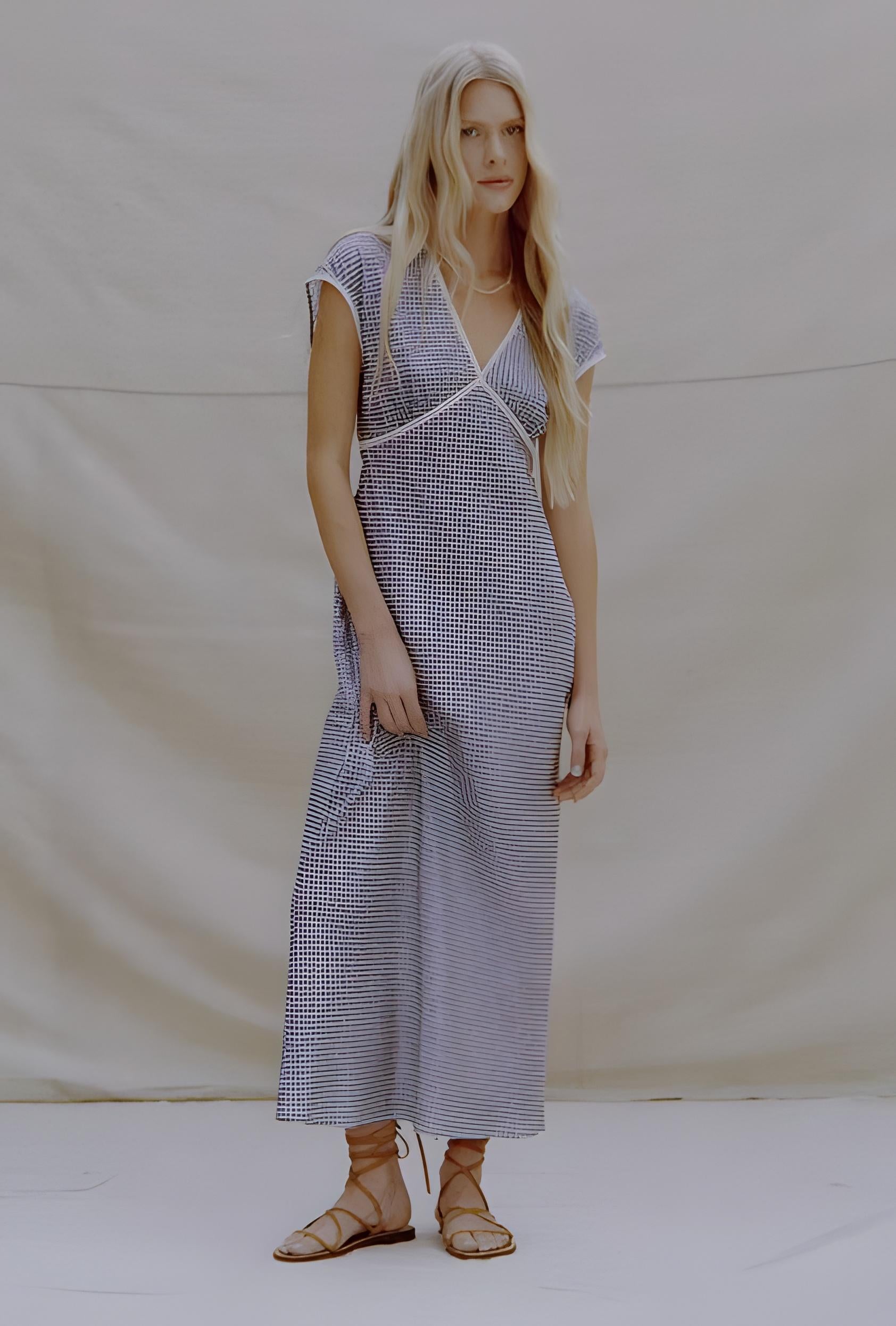 Woman wearing a checkered dress against a plain background