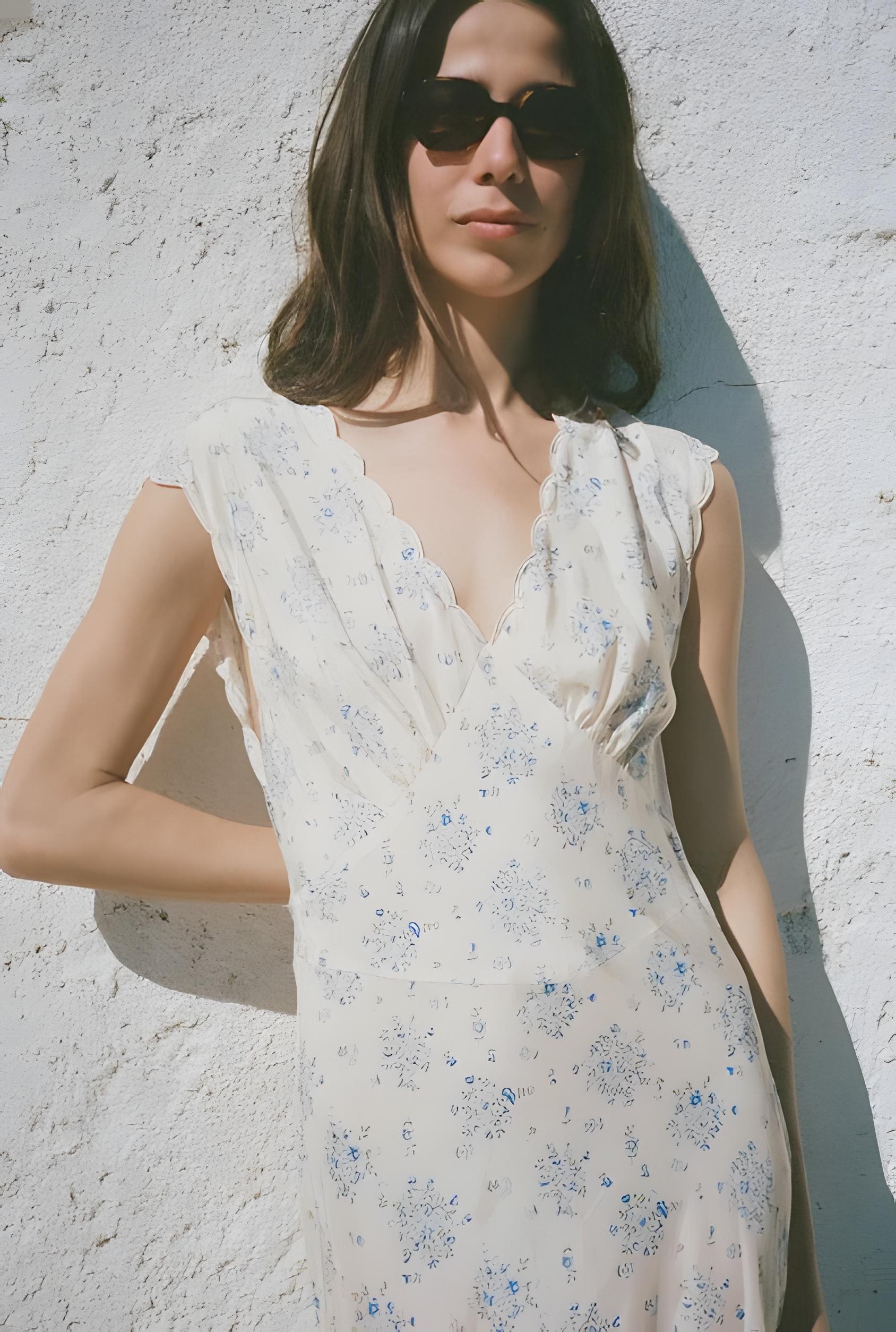 Woman wearing a floral dress against a light-colored wall