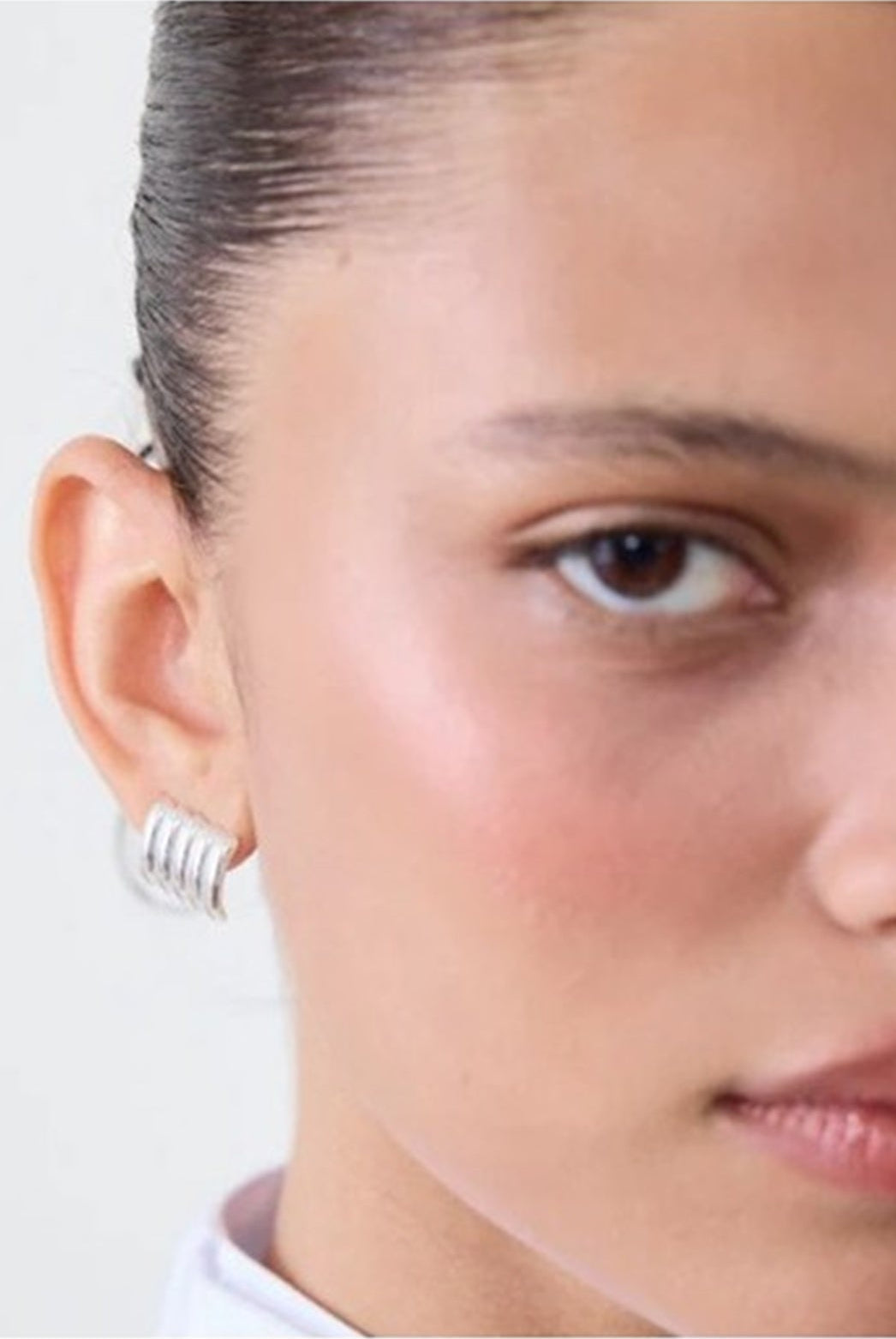 Close-up of a person's face with a neutral expression on a white background