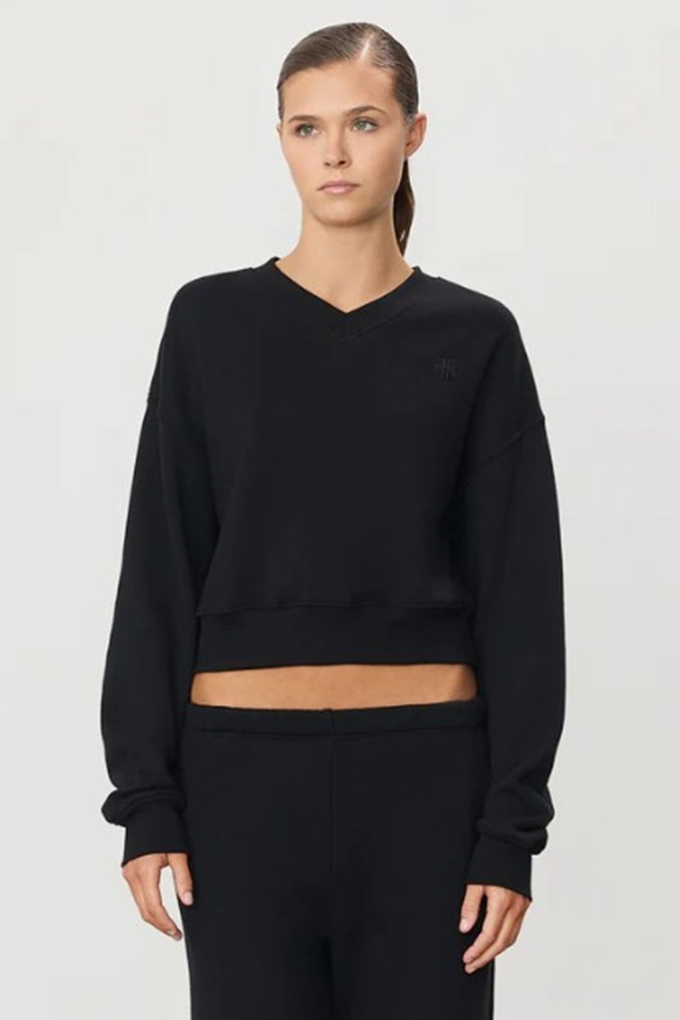 image of a model wearing the Eterne Cropped V Neck Sweatshirt in black