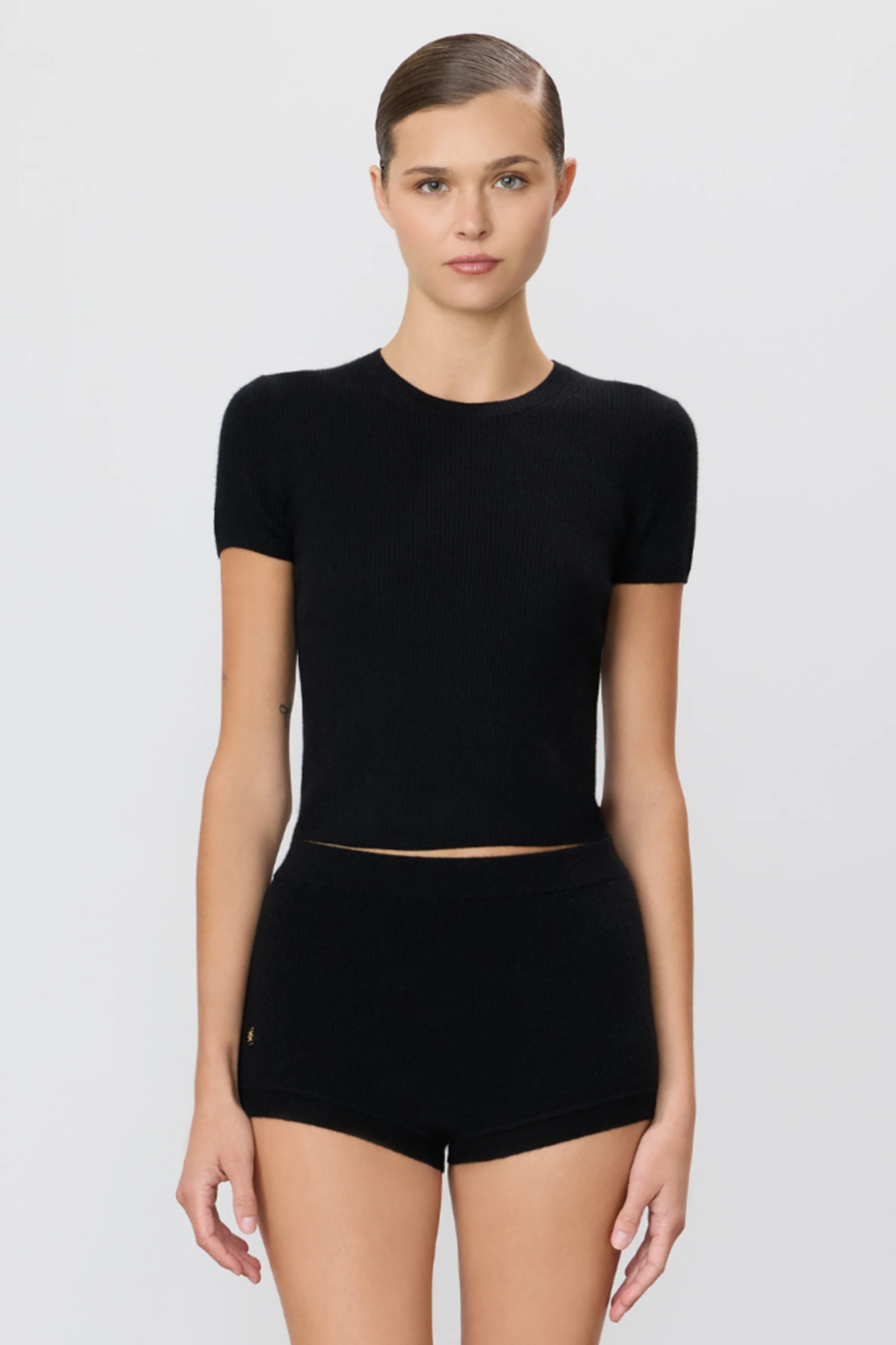 Person wearing a black cashmere top on a white background