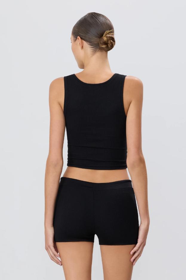 back of model wearing a black square necj tank top and black shorts on a light gray background