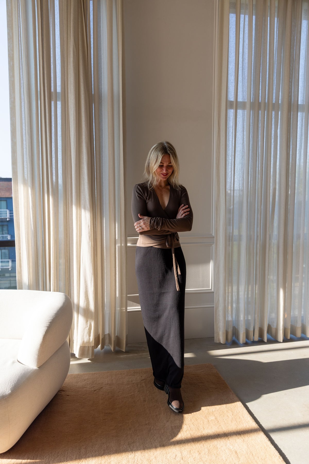 Eterne Wrap Top in mushroom modal jersey, full-length view styled with the Lisa Yang Charlotta Skirt in a sunlit room
