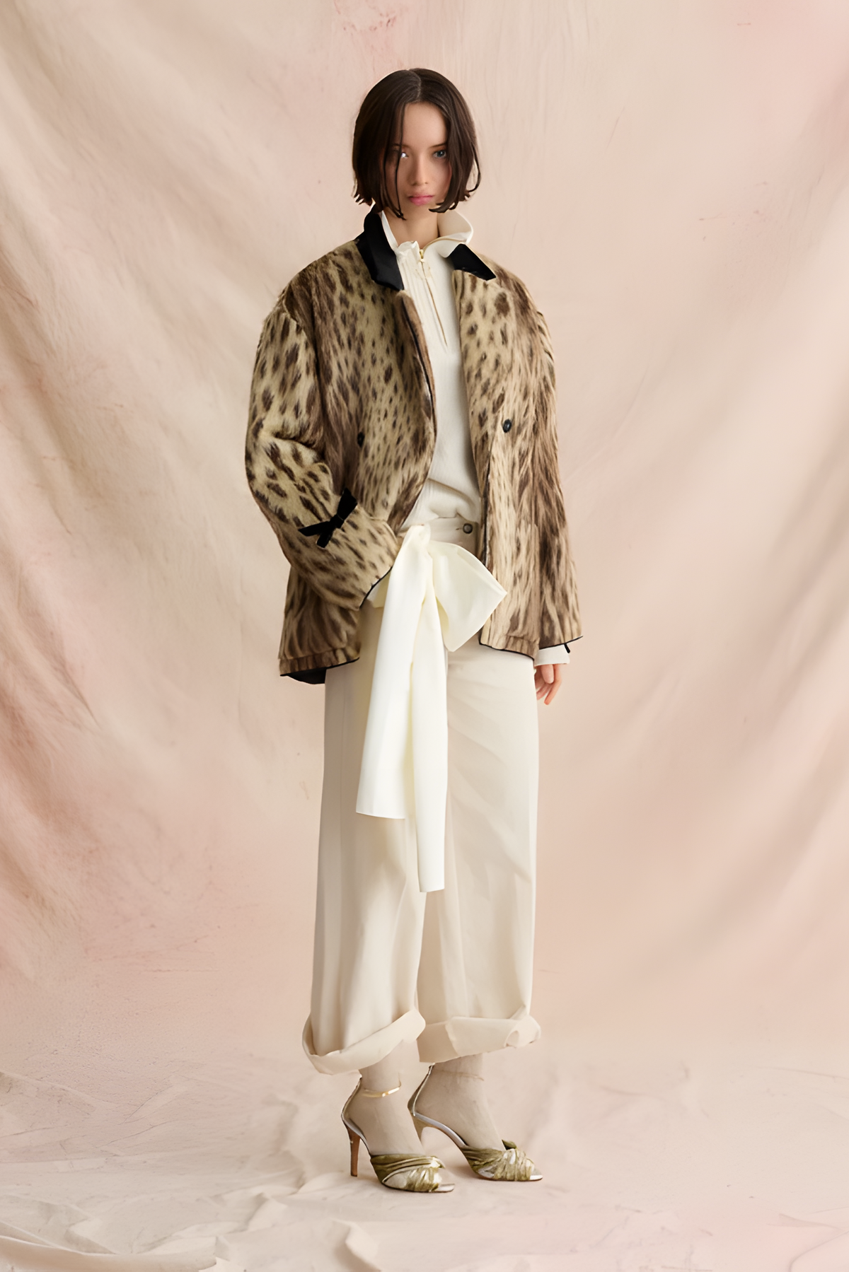 Model wearing the Forte Forte Royal Leopard Jacquard Double Breasted Coat in Giallo Oro, styled open over an ivory blouse and cream trousers against a blush backdrop