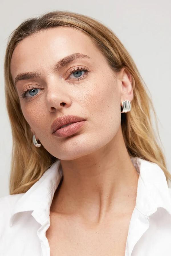 Woman wearing a white shirt with a plain background