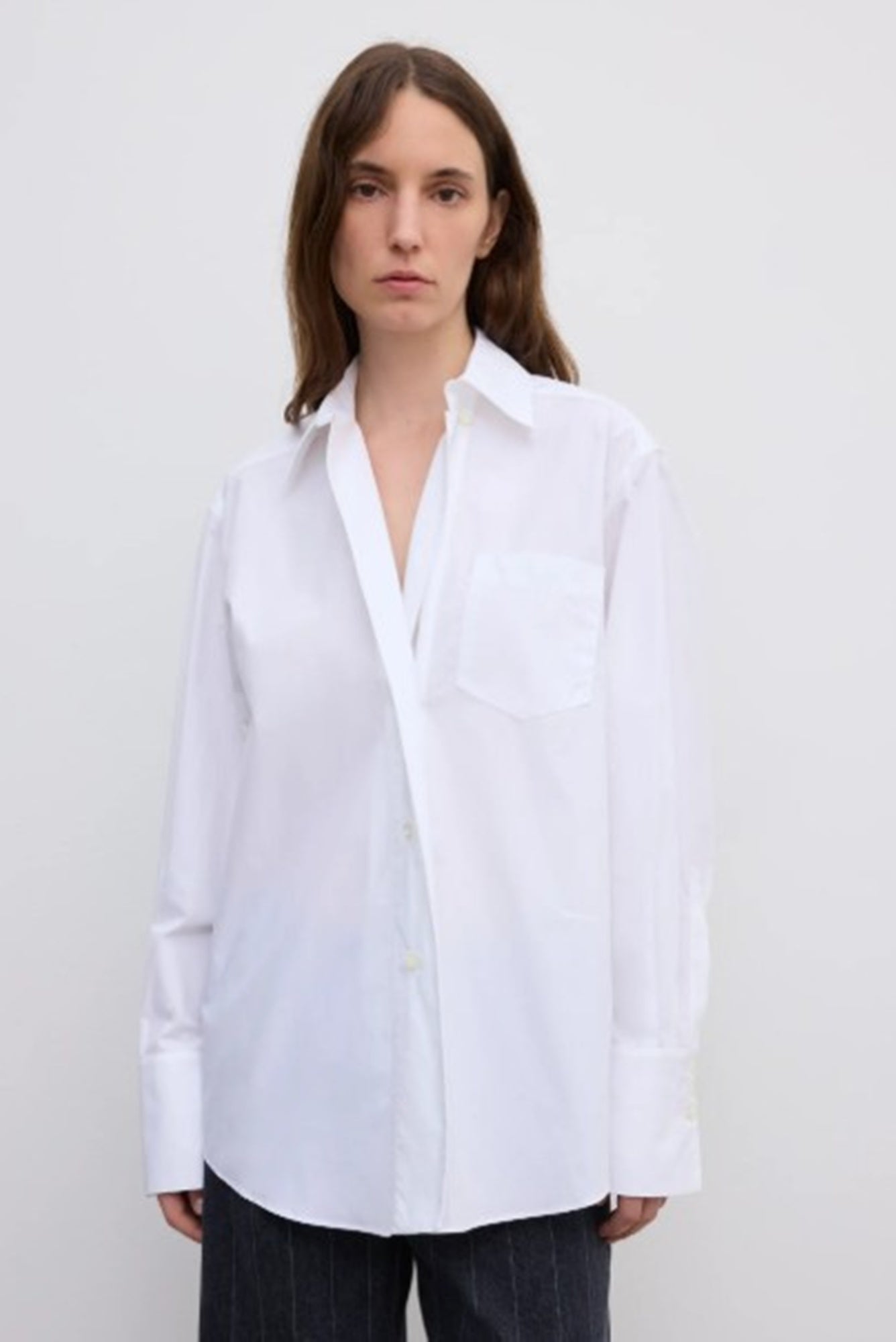 Person wearing a white shirt against a plain background