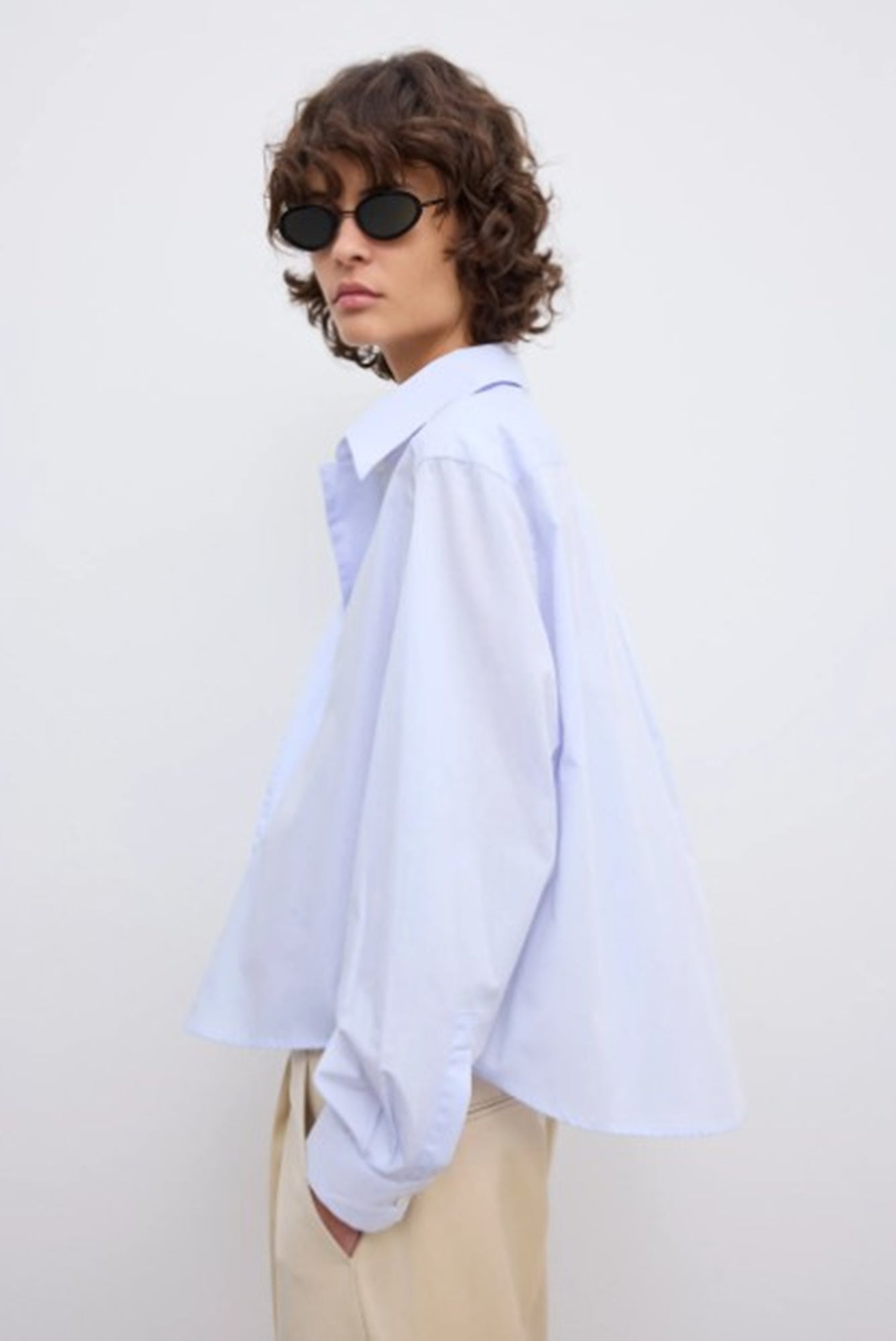 side image of a model wearing the House of Dagmar cropped shirt in light blue