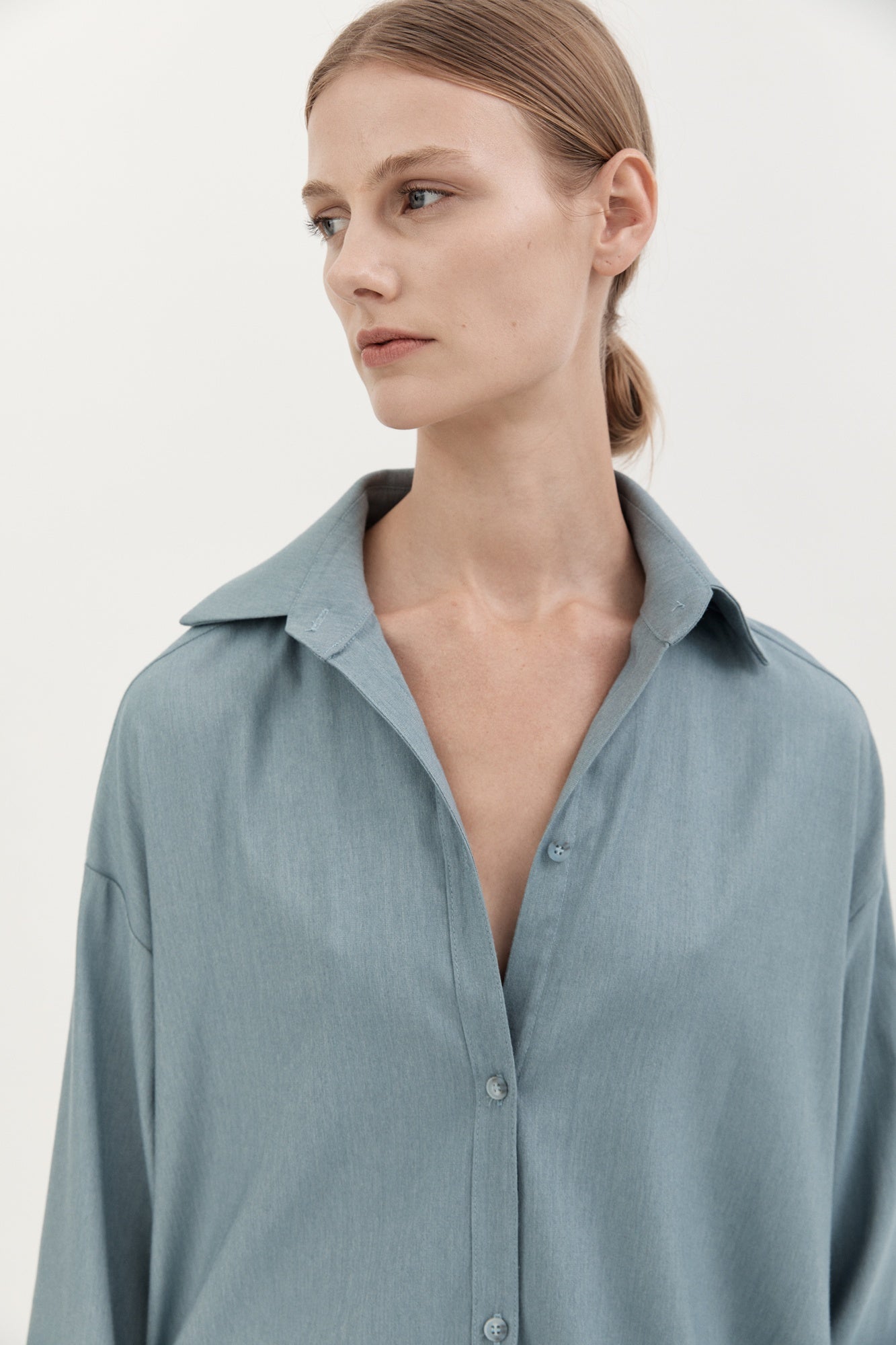 Woman wearing a light blue shirt against a white background
