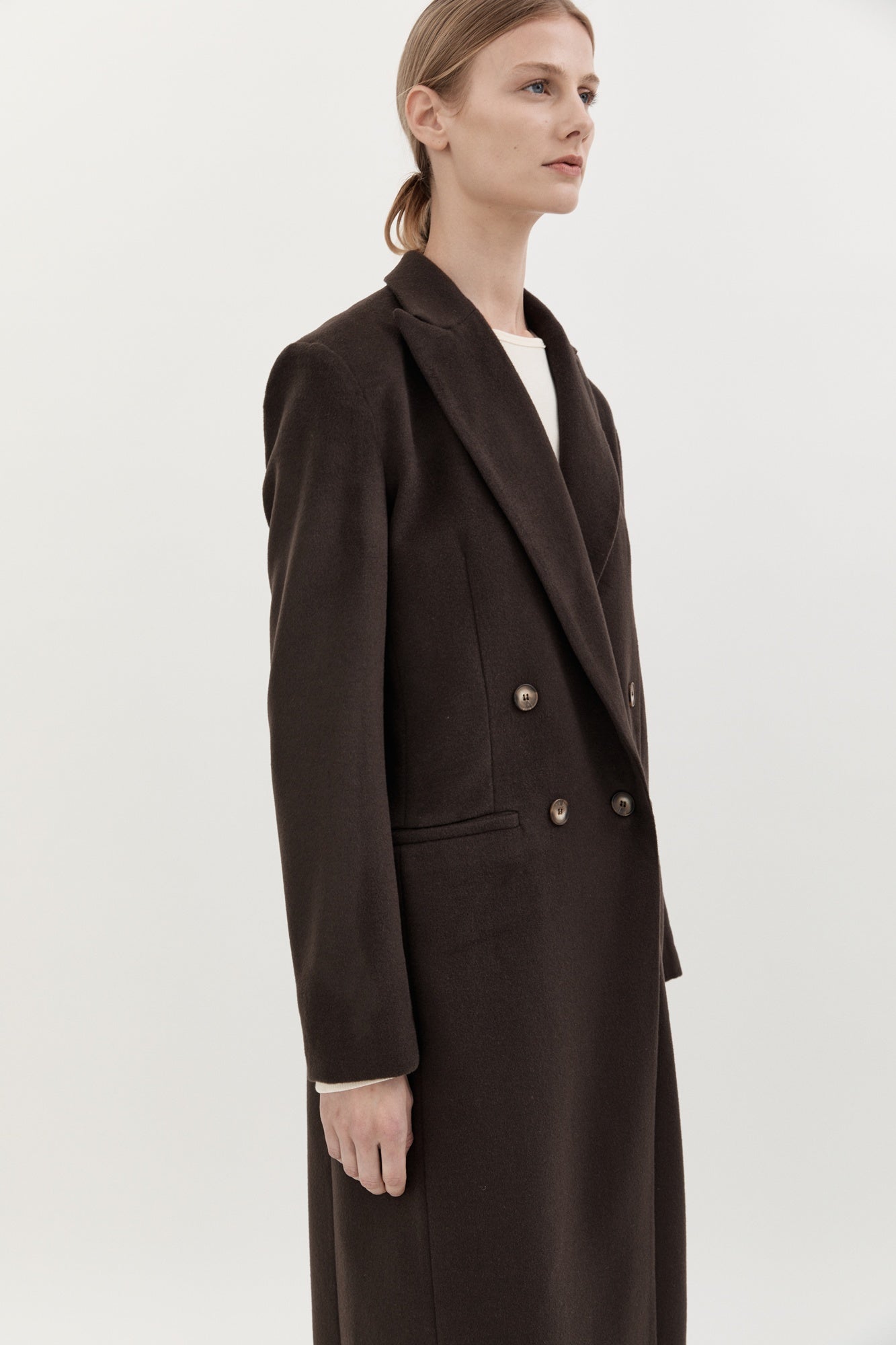 Woman wearing a brown coat on a white background