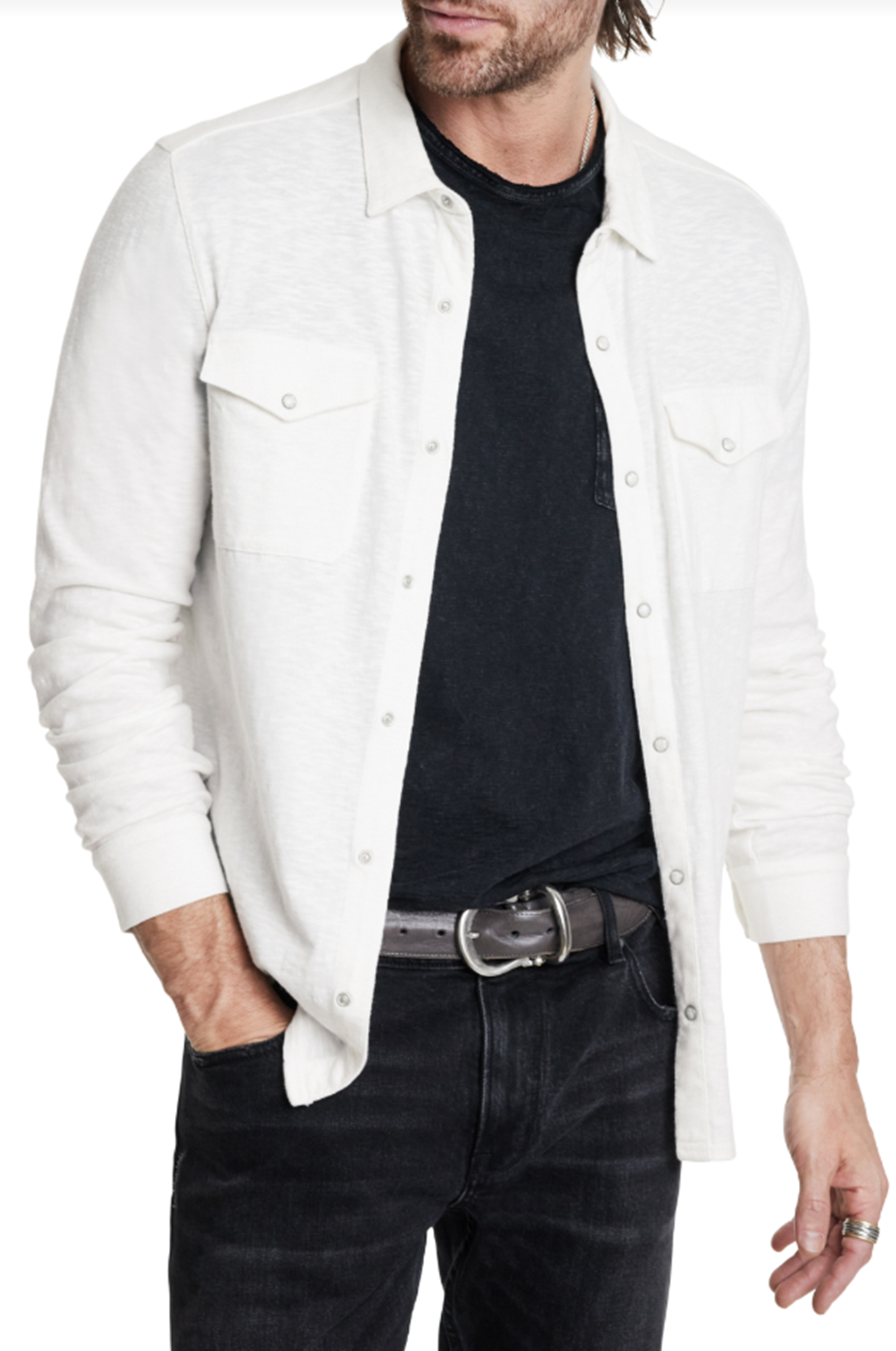 Man wearing a white denim jacket over a black shirt and jeans on a white background