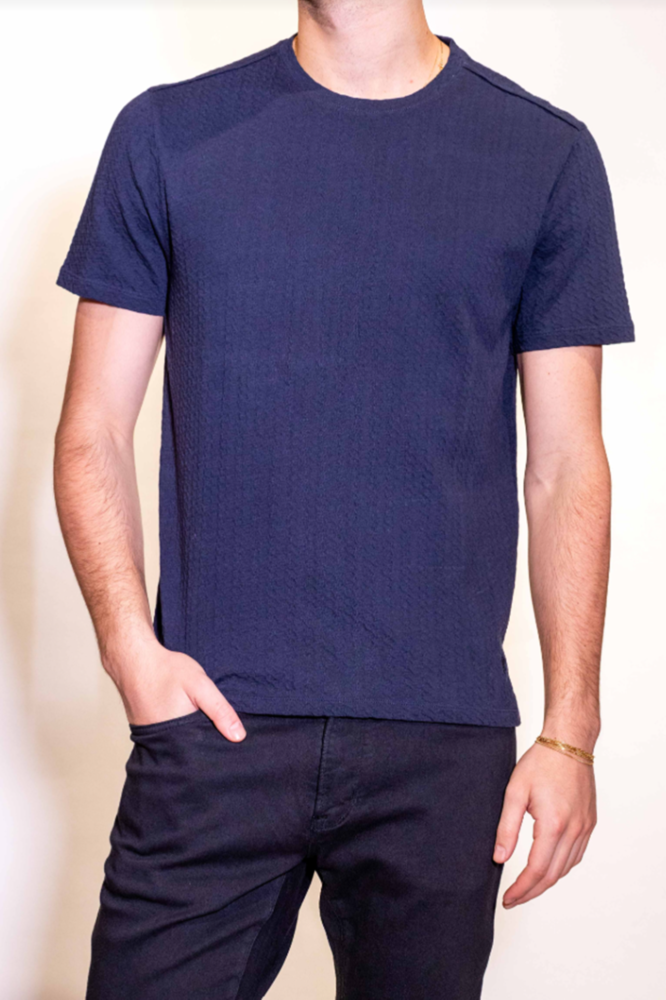 Person wearing a navy blue t-shirt and pants against a plain background