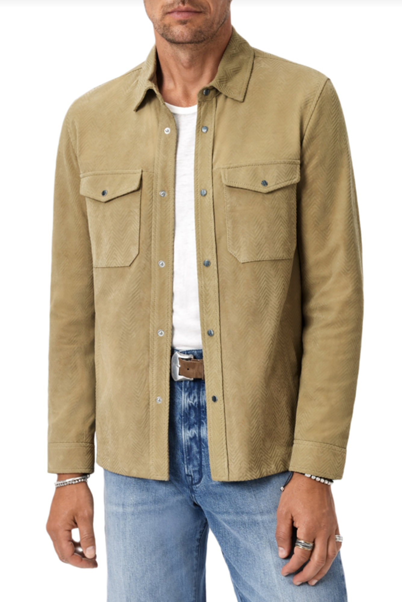Man wearing a herringbone shirt jacket over a white shirt and blue jeans on a white background