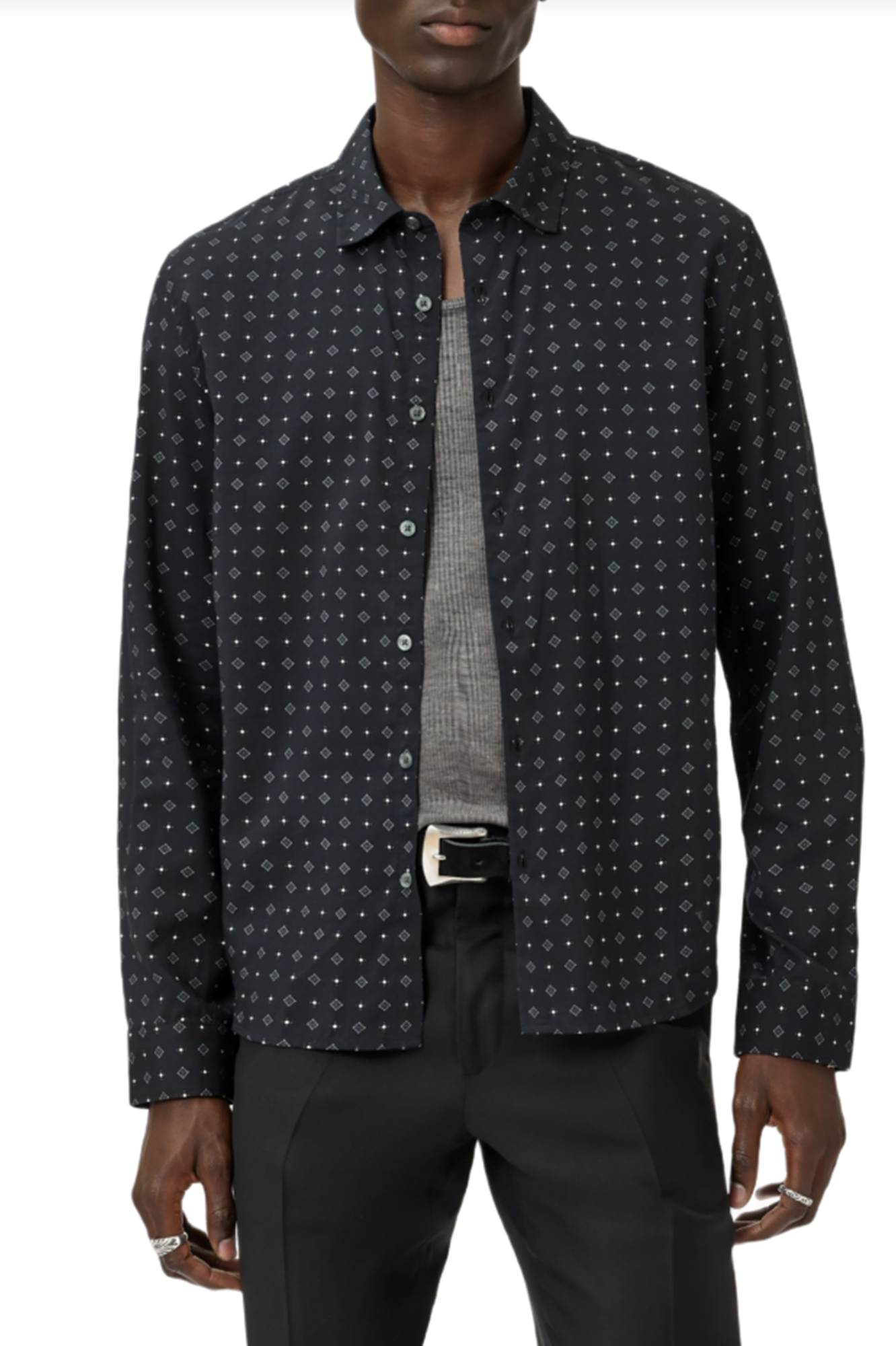 Man wearing a dark patterned shirt over a gray t-shirt on a white background