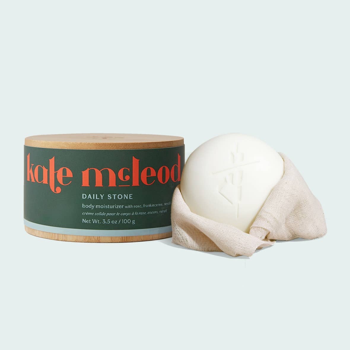 Body moisturizer with container labeled 'kate mcLeod' on a light gray background