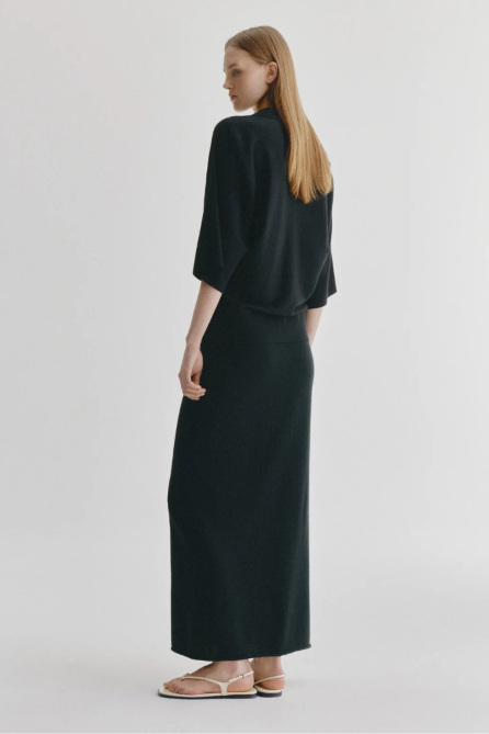 Woman wearing a black outfit on a plain background