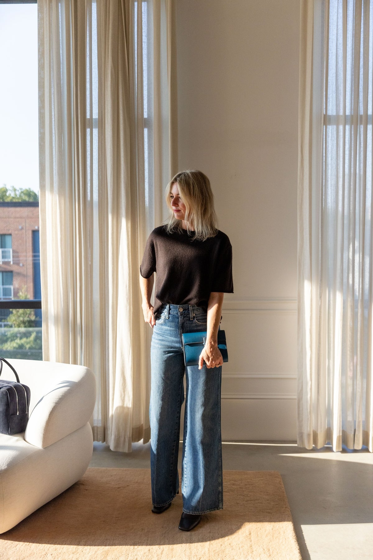 Lisa Yang Cila T-Shirt in dark oak with wide-leg AMO Frida jeans, full-length view in a sunlit room