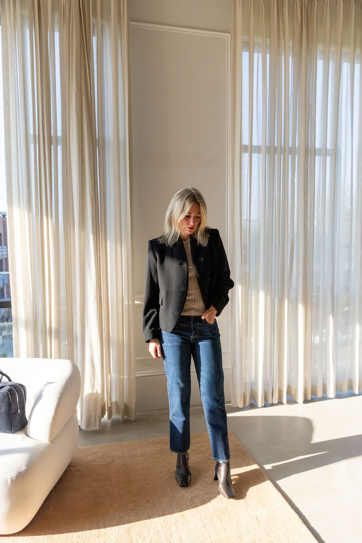 Lisa Yang Iora Top, Dagmar short curved jacket and AMO 143 jeans, full-length view in a sunlit room
