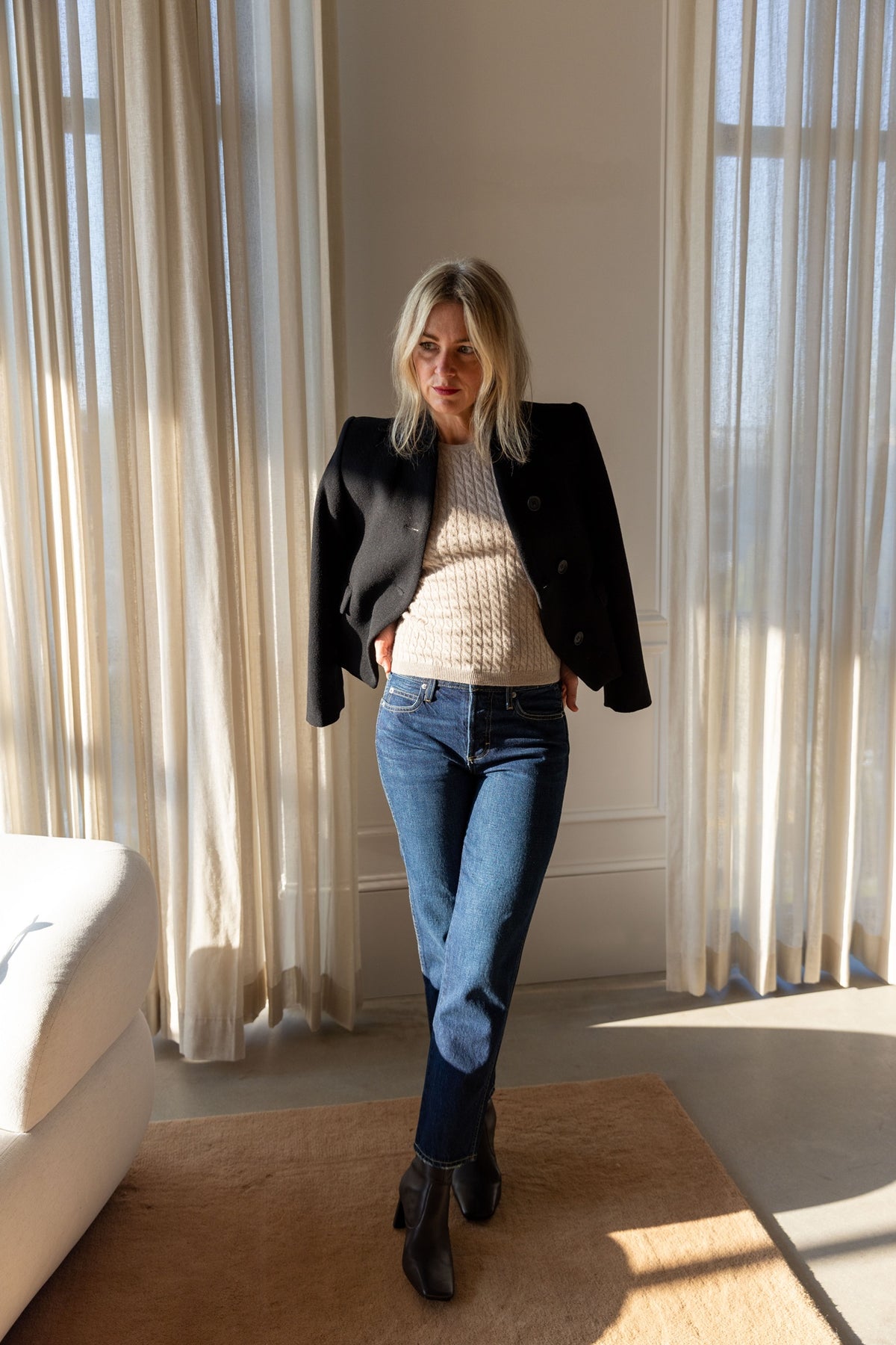 Lisa Yang Iora Top in sand with the Dagmar short curved jacket draped on the shoulders and AMO 143 jeans