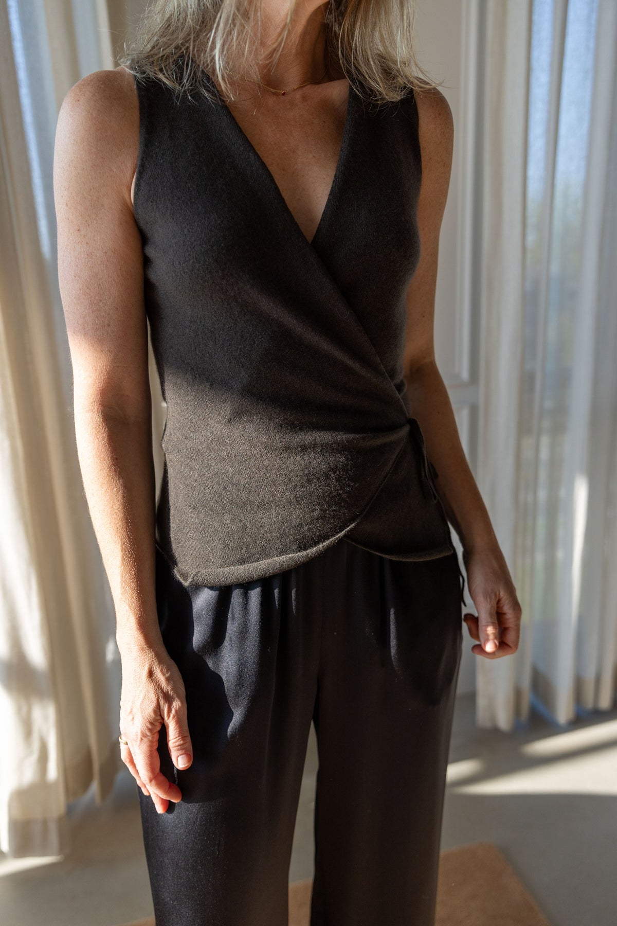 Lisa Yang Nayi Top in dark fern cashmere, sleeveless wrap style, styled with Sablyn Brynn silk pants