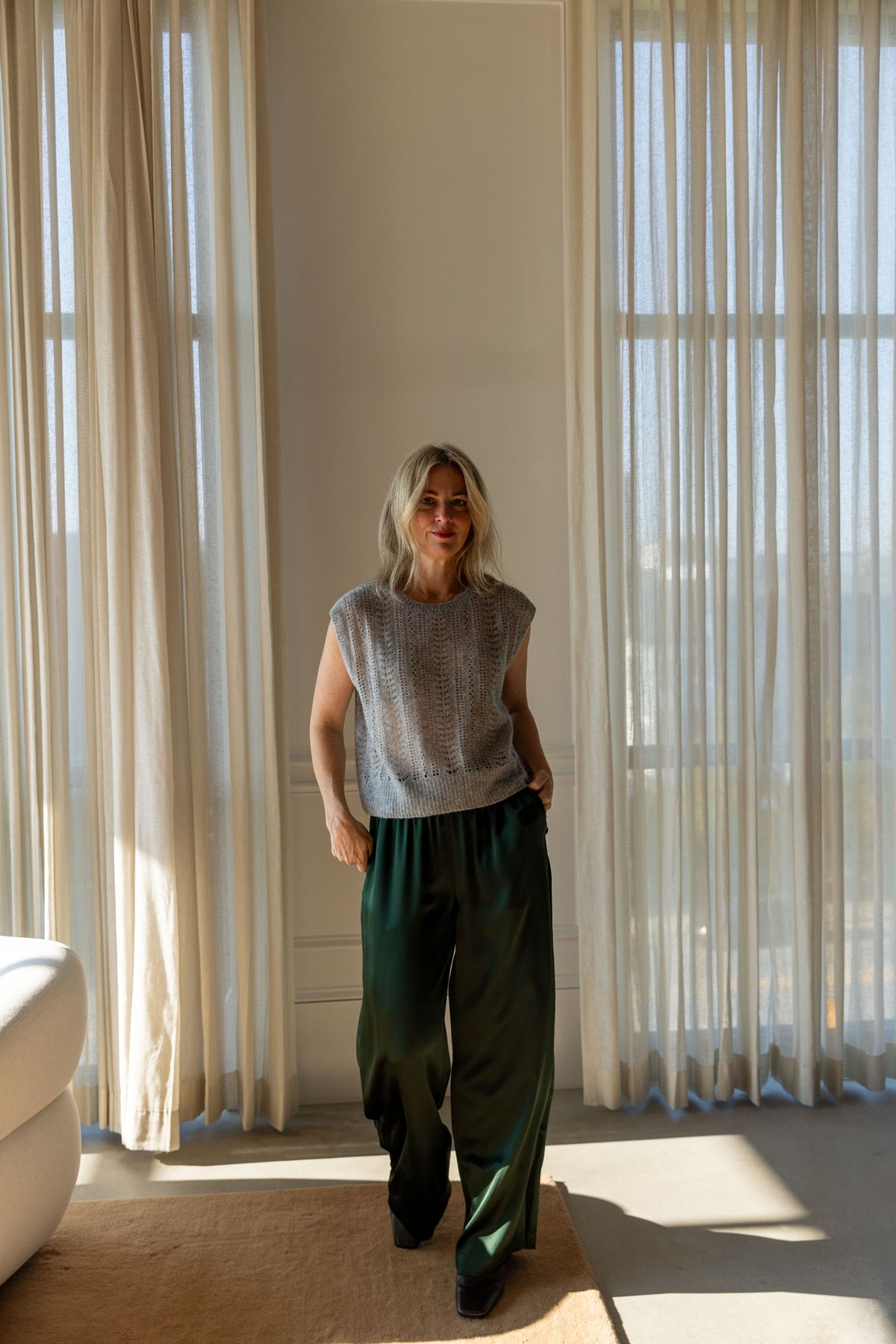 Lisa Yang Nian Vest in cloudy grey with green Sablyn Brynn silk pants, full-length view in a sunlit room