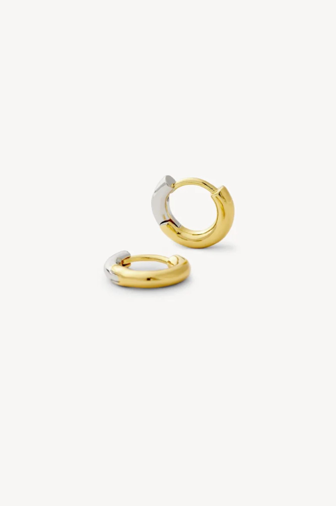 Two gold hoop earrings on a white background