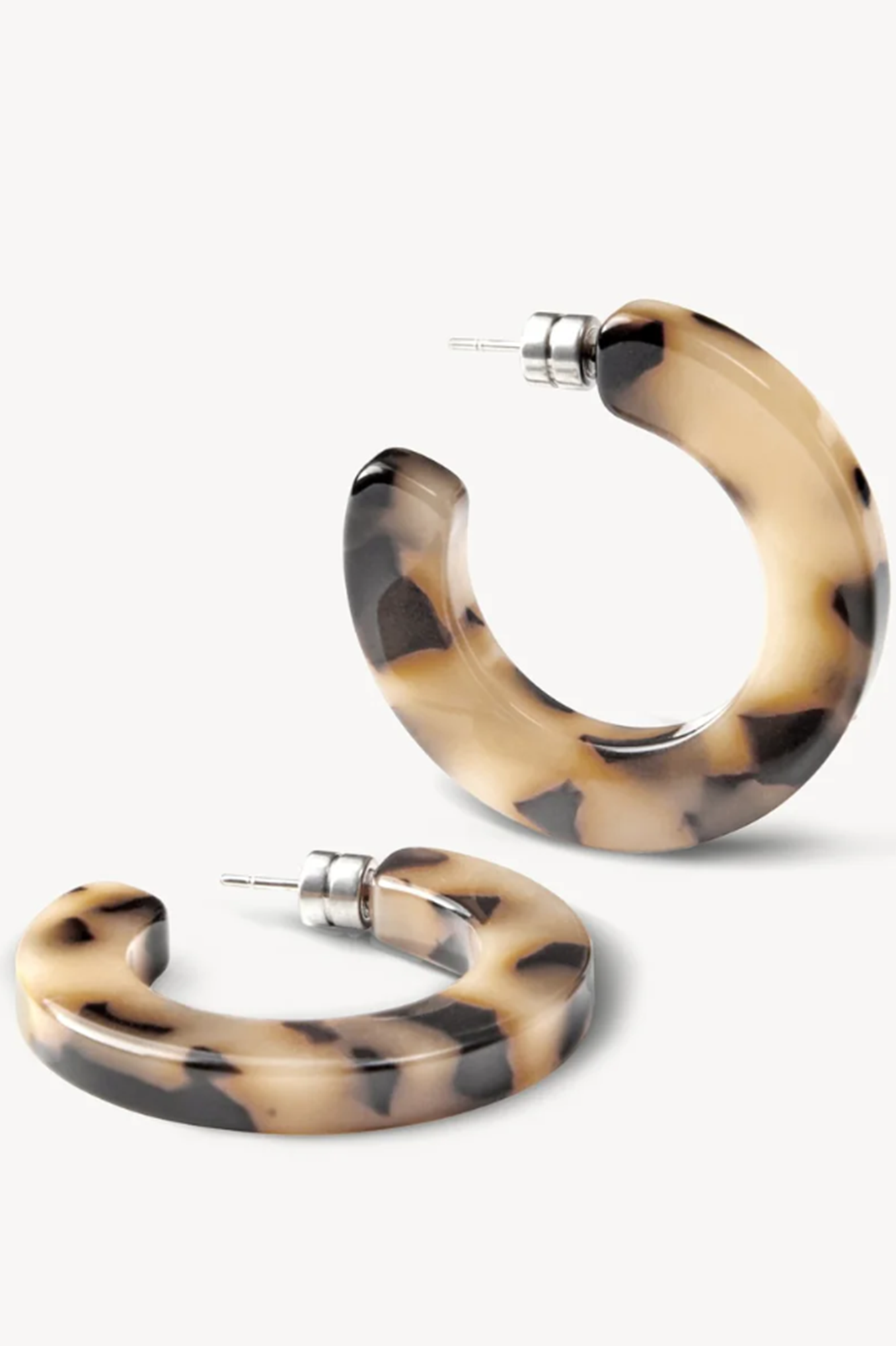 Pair of tortoiseshell hoop earrings on a white background