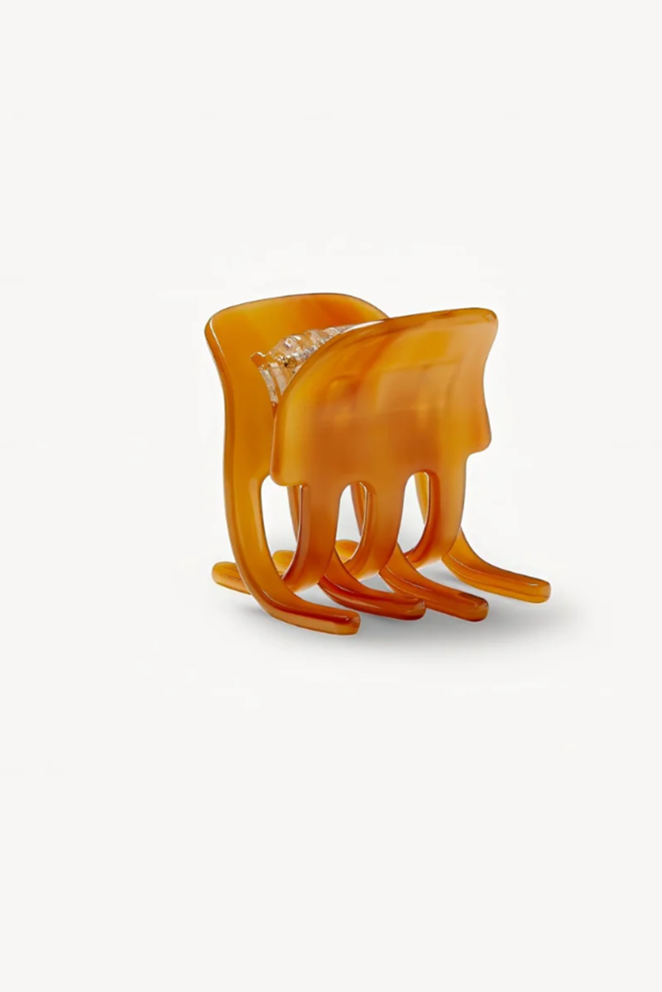 Three cognac hair clips or claws on a white background