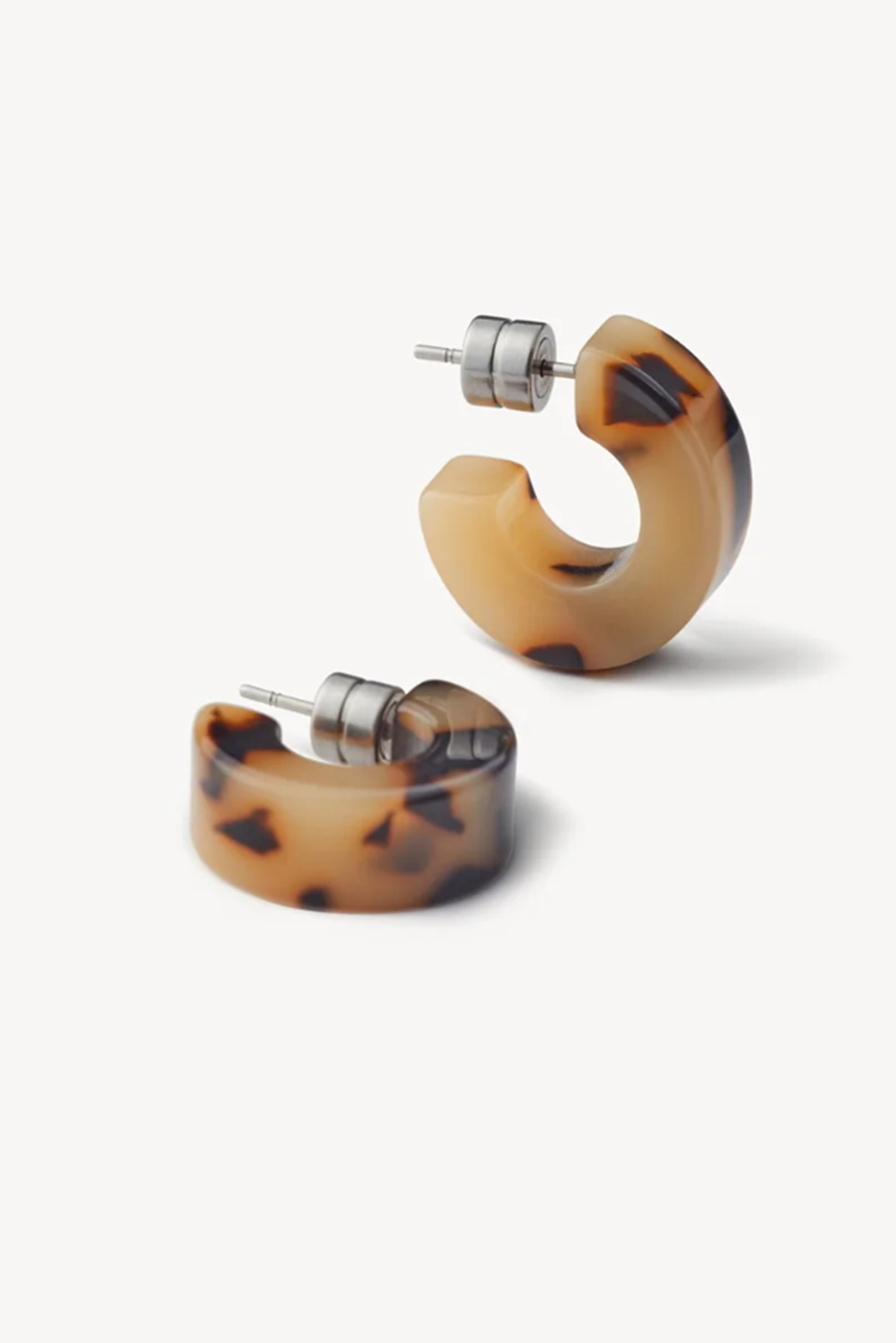 Pair of tortoiseshell hoop earrings on a white background