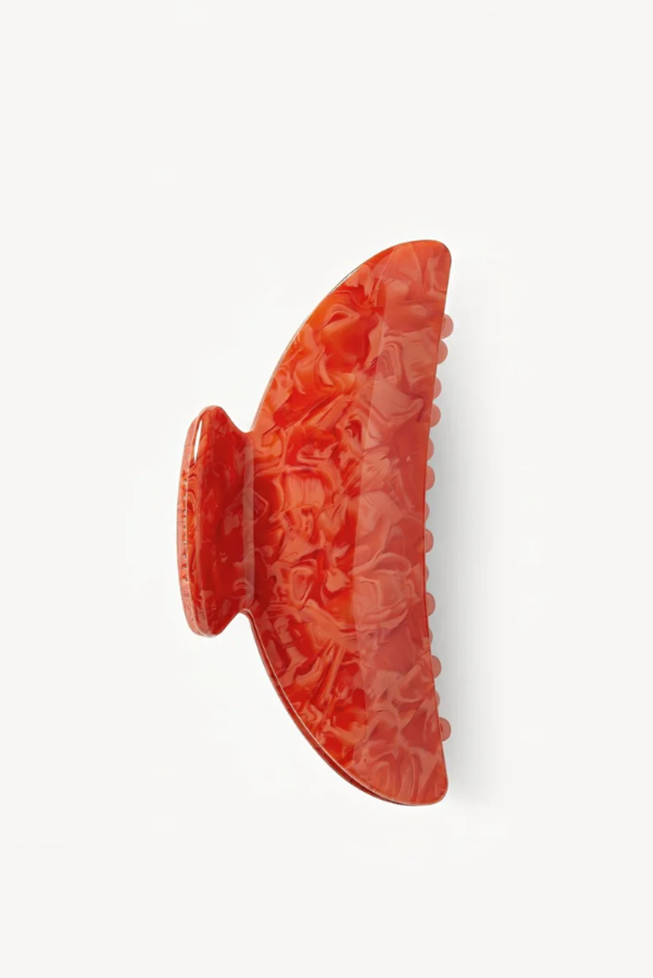 Decorative corla or poppy-colored object with intricate patterns on a white background