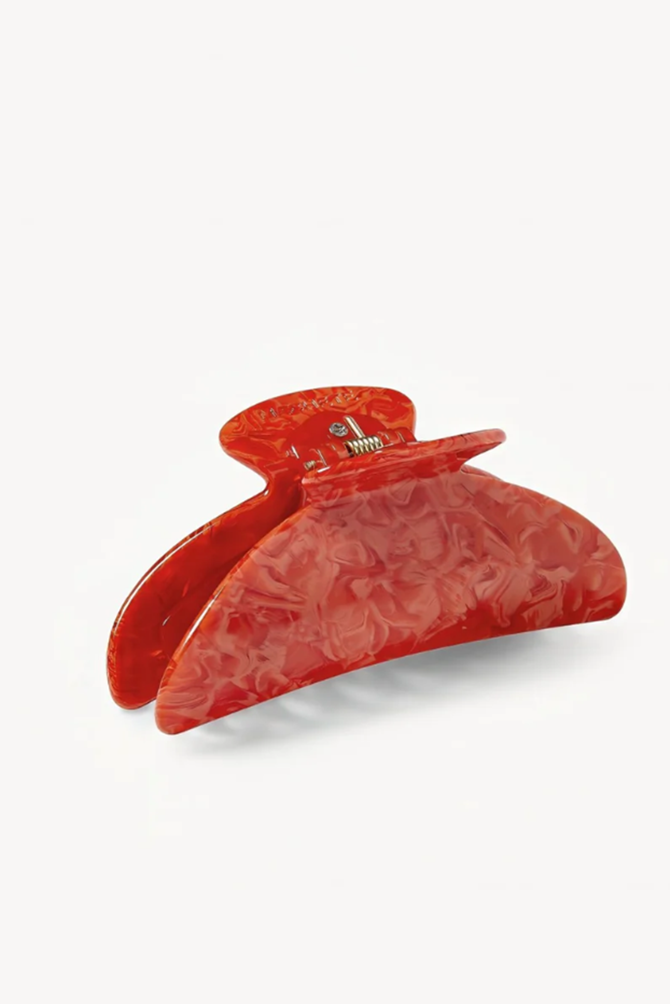 Coral or poppy colored hair clip on a white background
