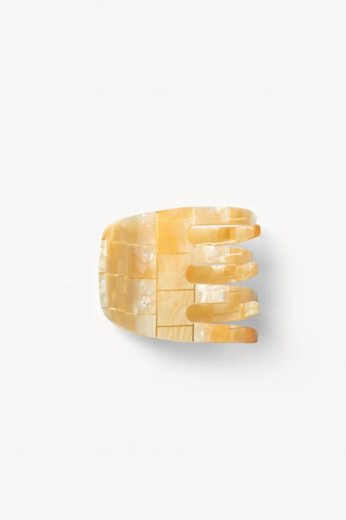 Side view of a sea shell textured hair clip or claw on a white background. 