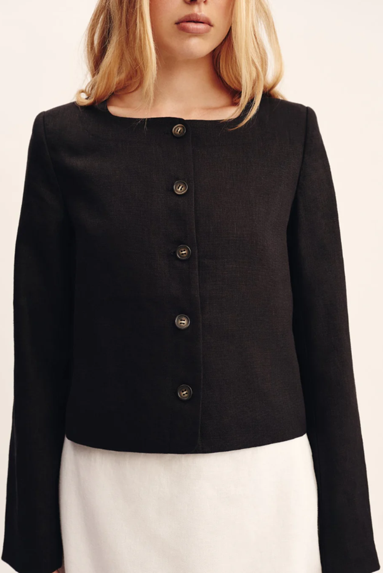 Black jacket with button details on a plain background