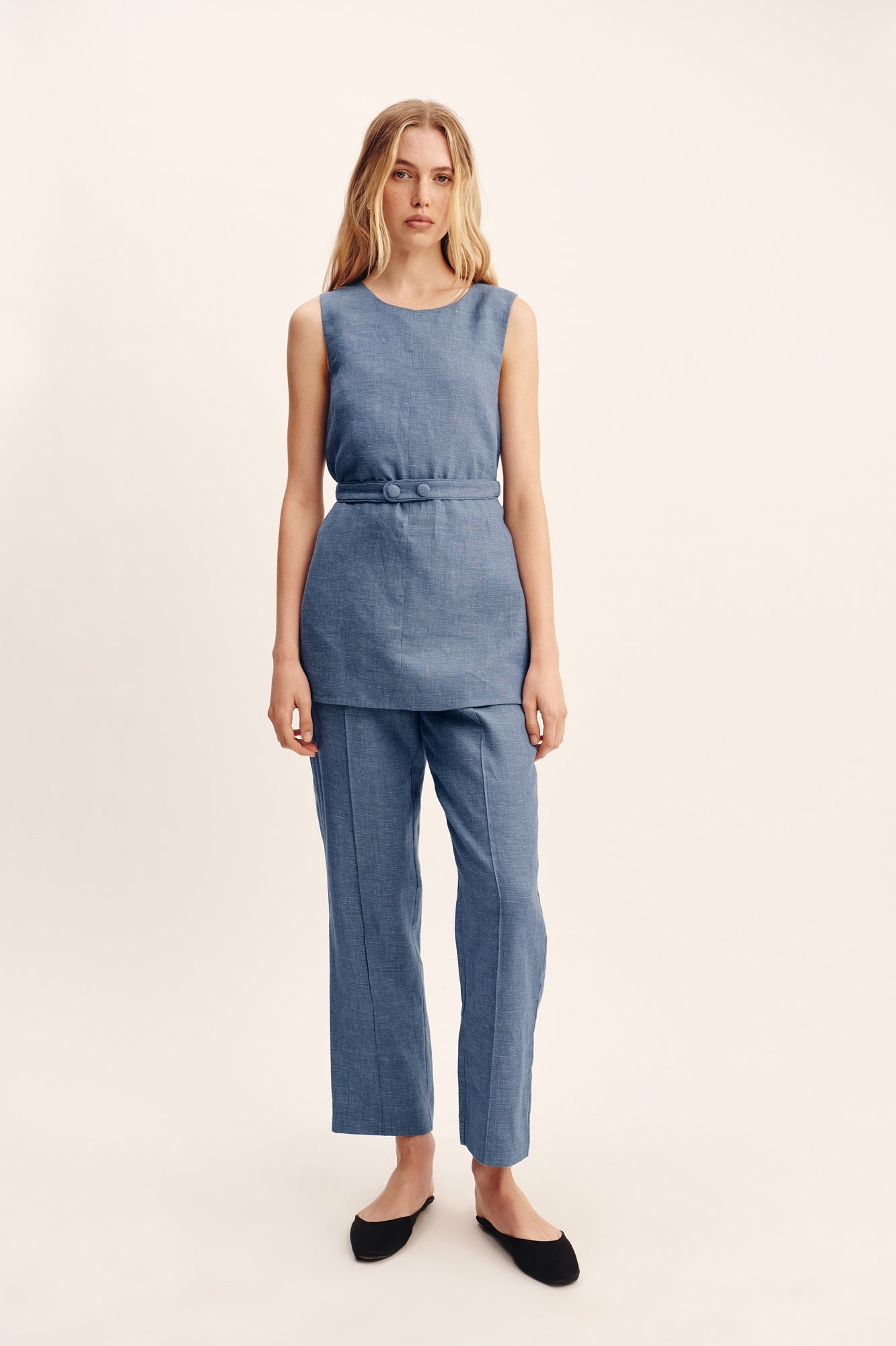 Woman wearing a blue jumpsuit on a white background