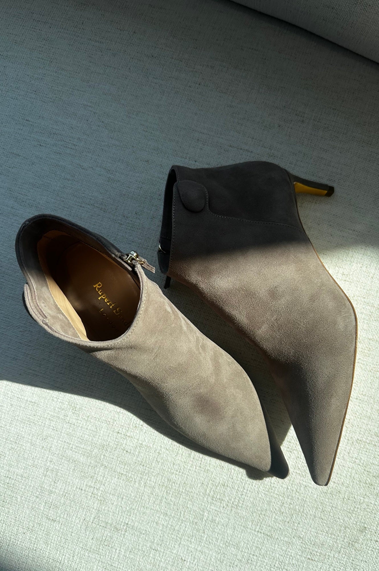 Pair of gray suede ankle boots on a textured surface