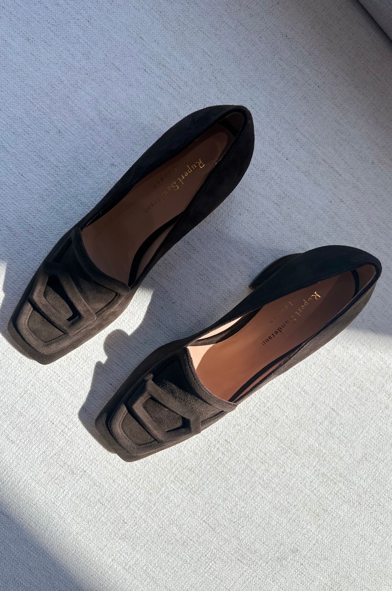 Pair of black loafers on a light gray surface