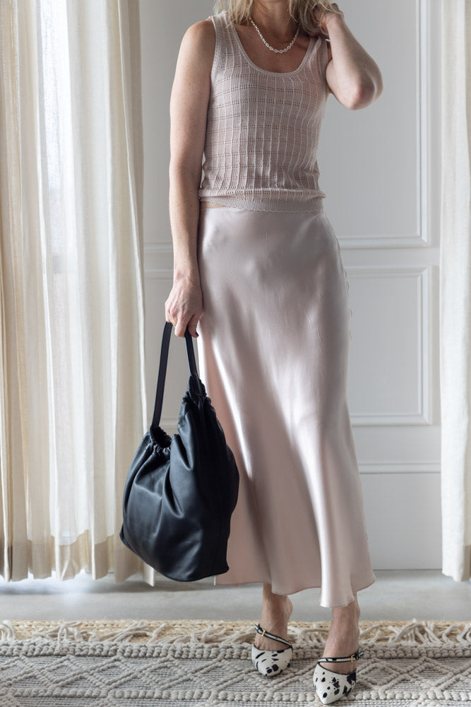 image of a woman wearing the Sablyn Cordelia B Scoop Neck Tank and Miranda Skirt in Lunar with the Aesther Ekme Demi Lune Cloud Bag