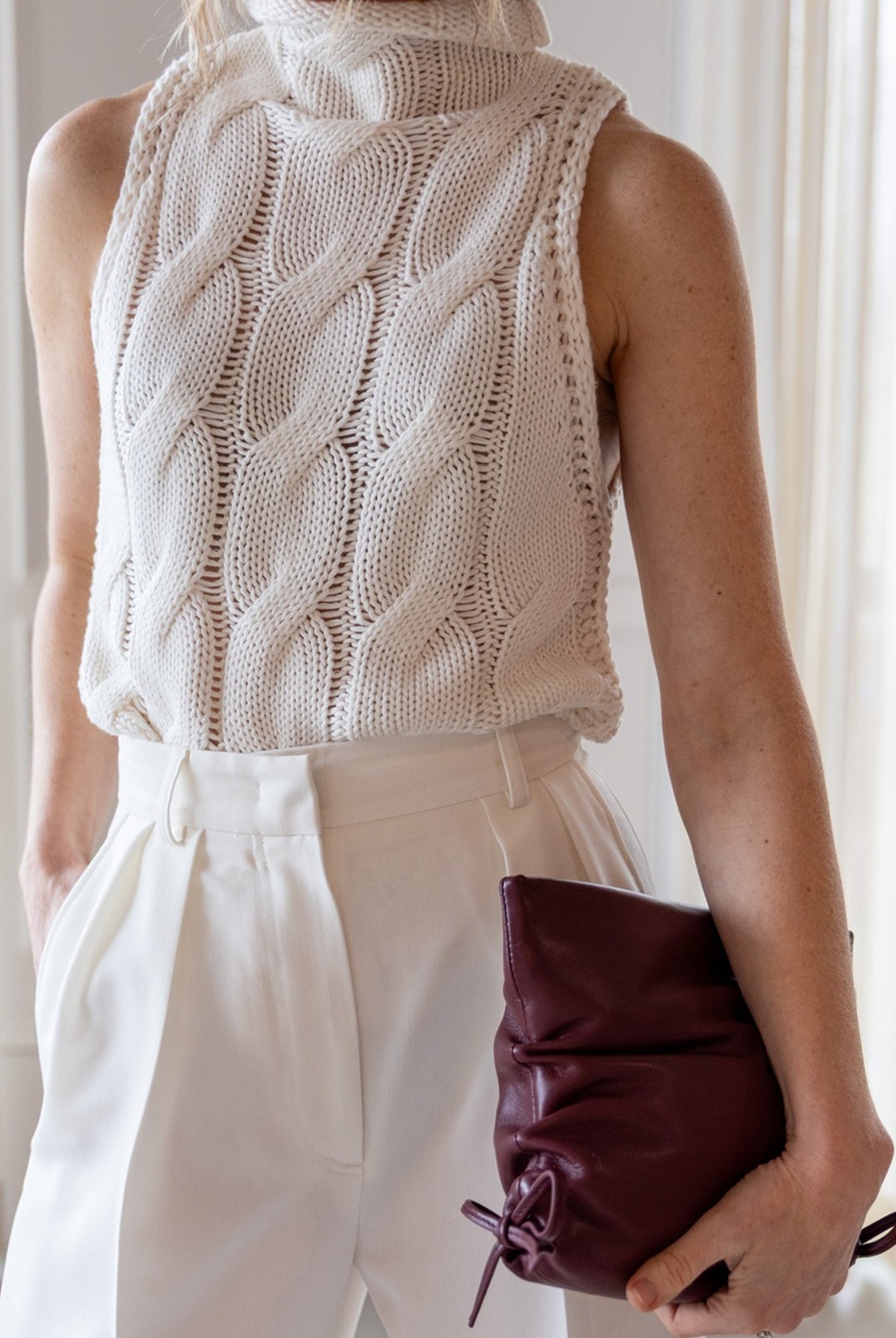 close up image of a woman wearing the Sablyn Salvia Knit Top and Rhune Celine Pants