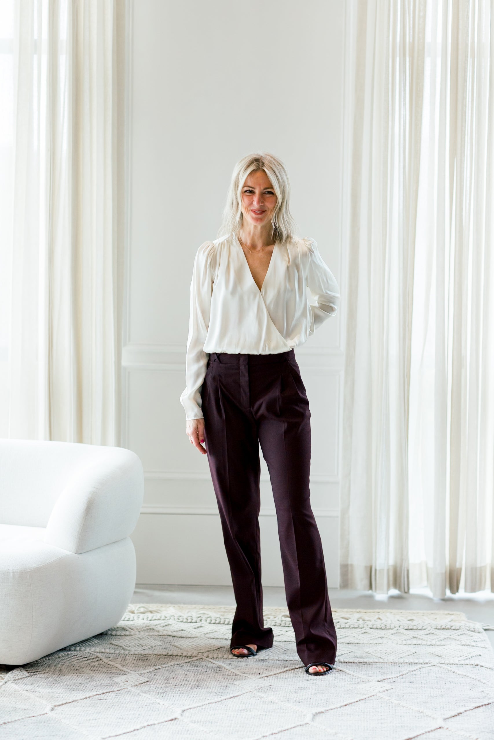 image of a woman wearing the garment catania blouse in cream and necchi pants