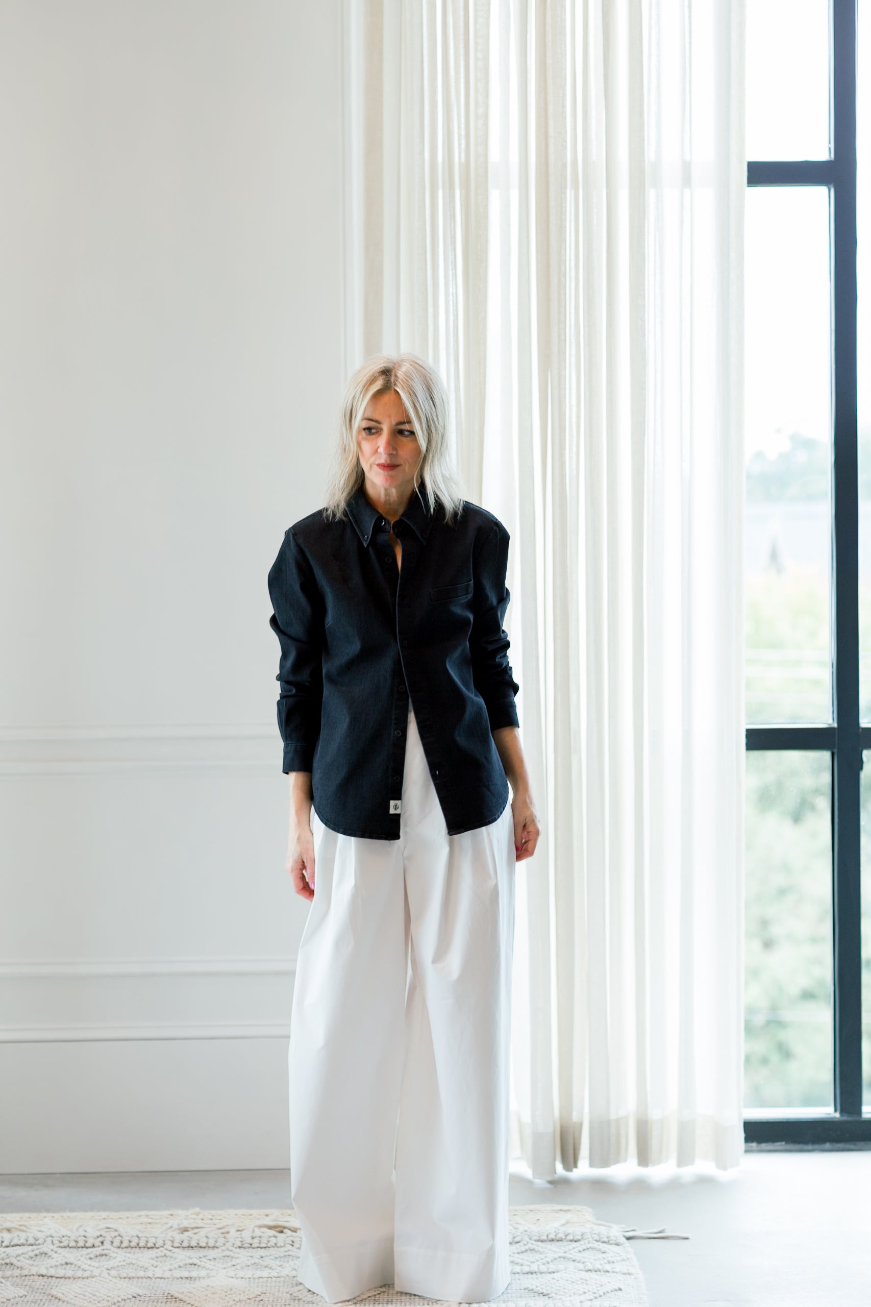 image of a woman wearing the garment merci placket shirt and avelino pants